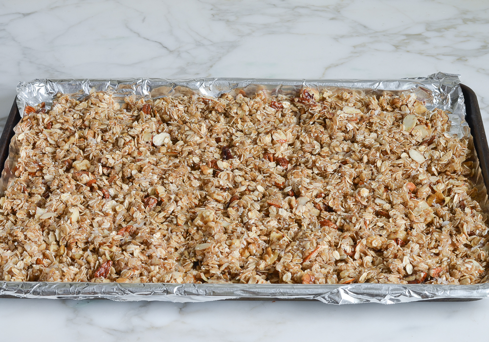 homemade granola mixture ready to bake on foil-lined baking sheet