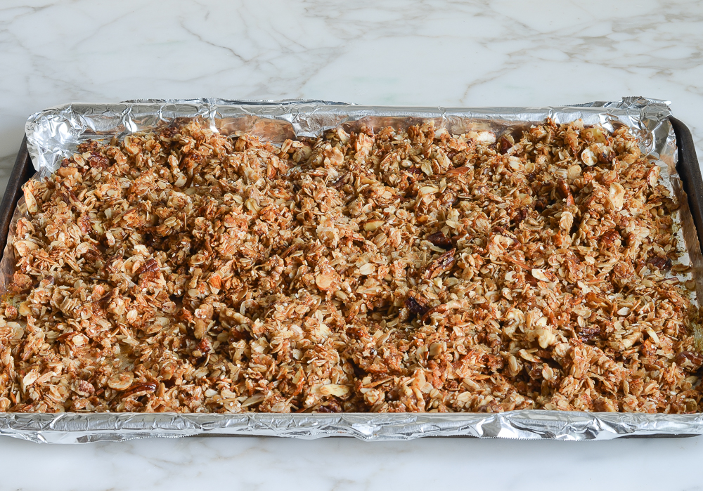 baked golden brown granola mixture on foil-lined baking sheet