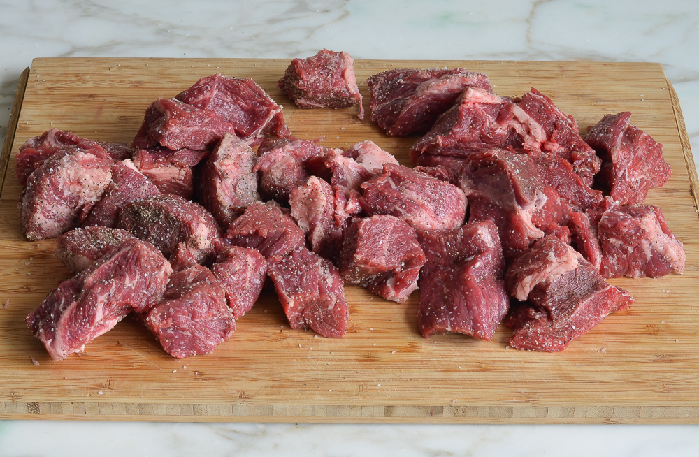 Seasoned beef on a cutting board.