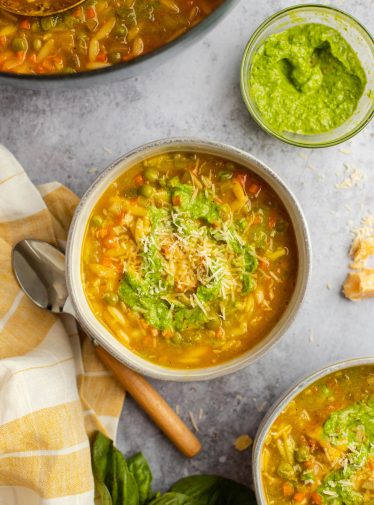 bowls of vegetable soup with spoon and linen napkin