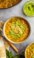 bowls of vegetable soup with spoon and linen napkin