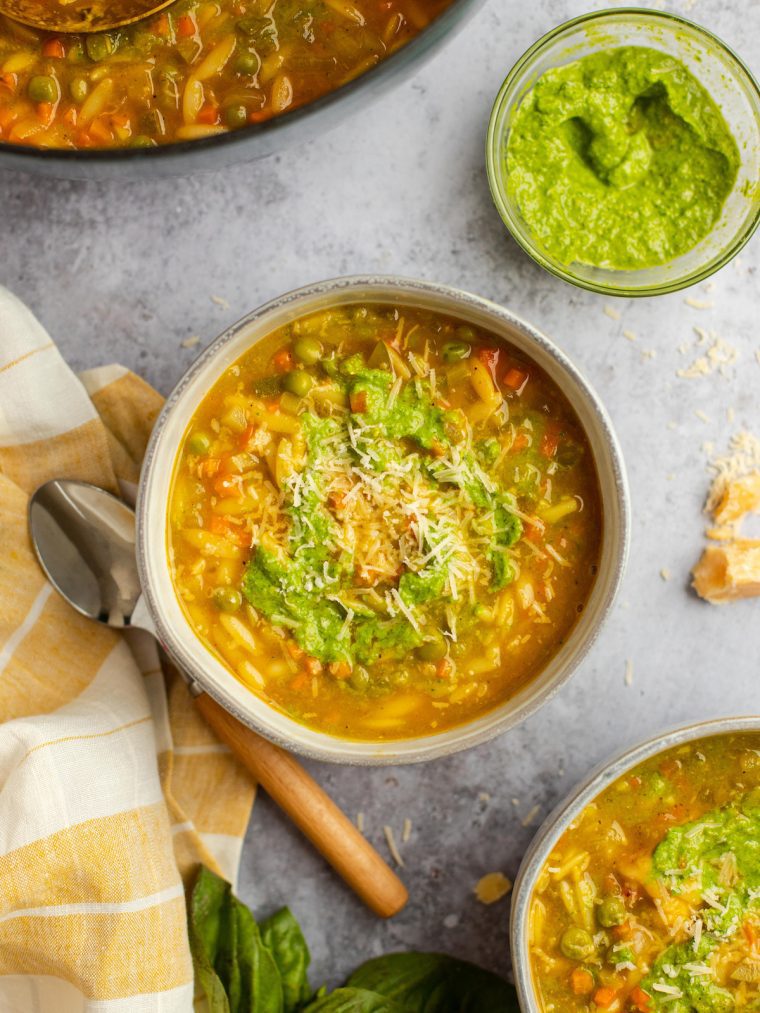 bowls of vegetable soup with spoon and linen napkin