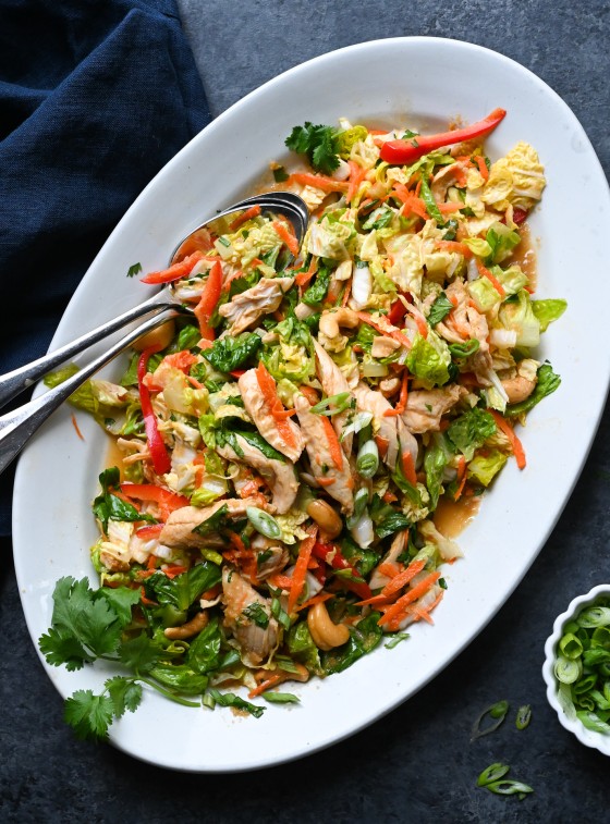 Spoons in a platter of Chinese chicken salad.