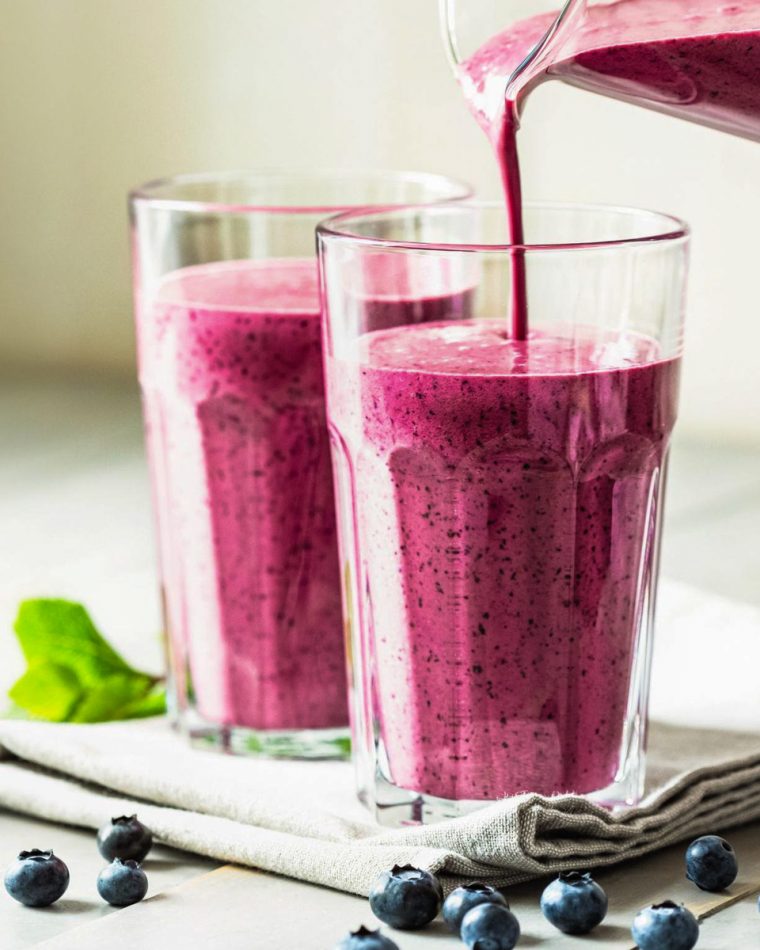 pouring berry smoothie into glasses