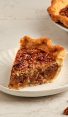 slice of bourbon pecan pie on white plate