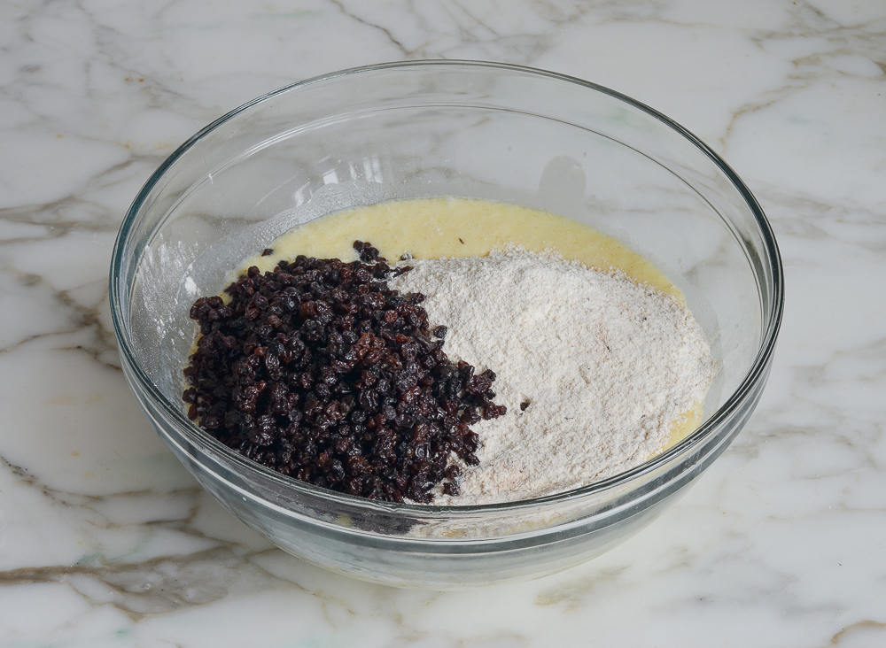 adding dry ingredients and currants to liquid ingredients for irish soda bread muffins
