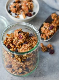 Granola in and around a glass jar.