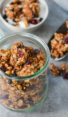 Granola in and around a glass jar.