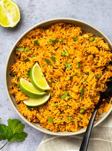 bowl of mexican rice with lime wedges