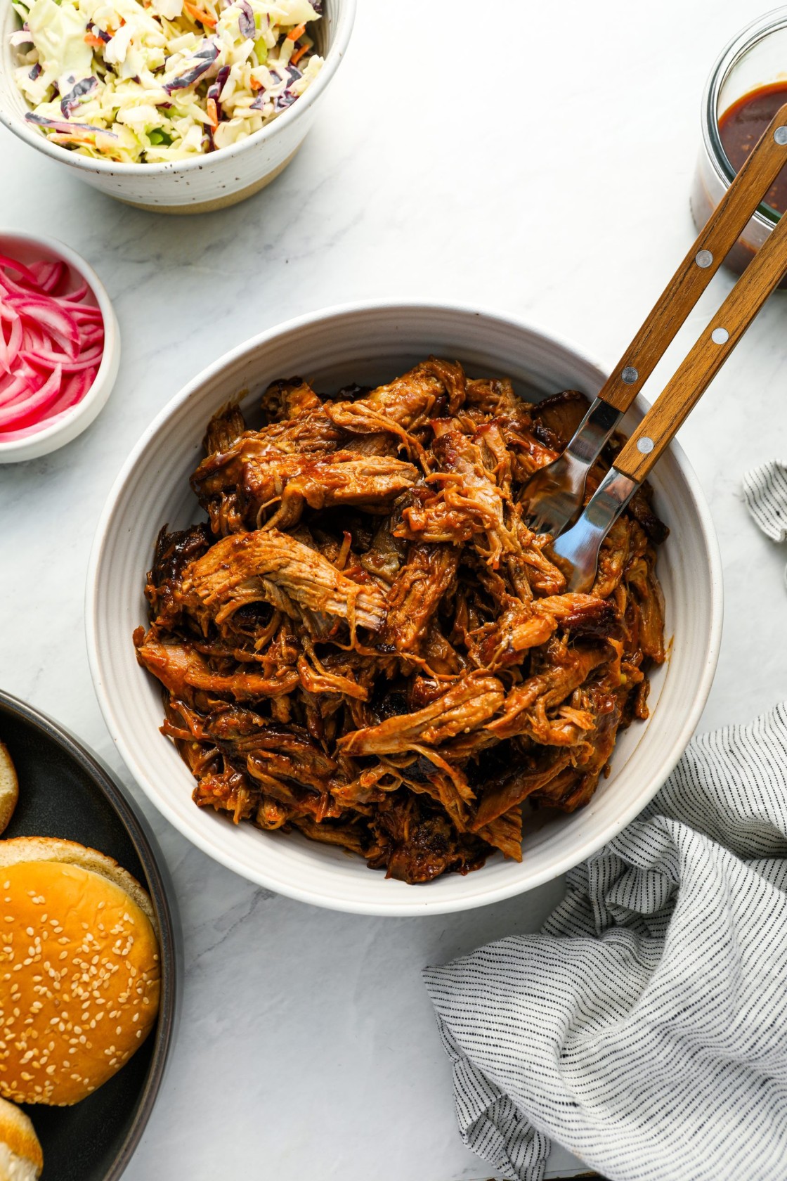 pulled pork with buns, coleslaw, pickled onions, and BBQ sauce