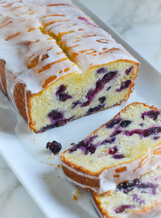 Loaf of lemon blueberry pound cake with some slices removed.