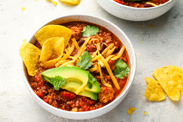 bowls of turkey chili topped with all the fixings