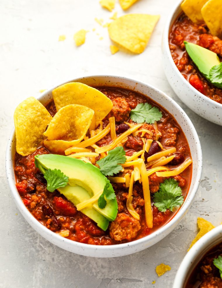 bowls of turkey chili topped with all the fixings