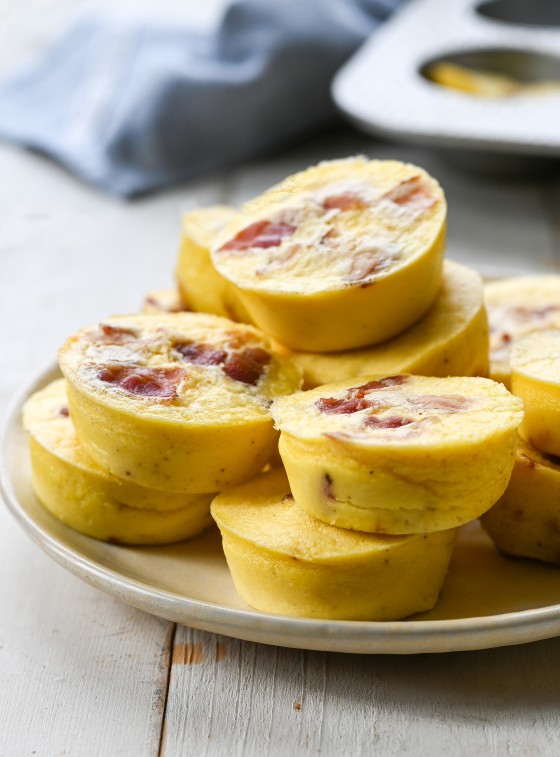 Egg bites with bacon and gruyere piled on a plate.