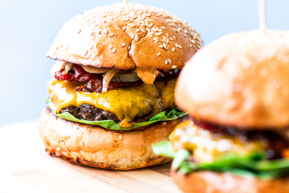 Smash burgers on a cutting board.