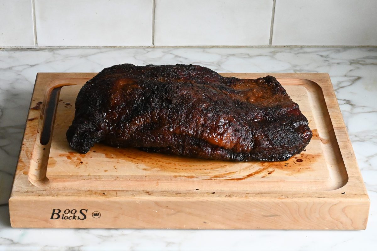 partially smoked brisket on cutting board