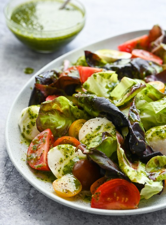 Plate of salad topped with basil vinaigrette.