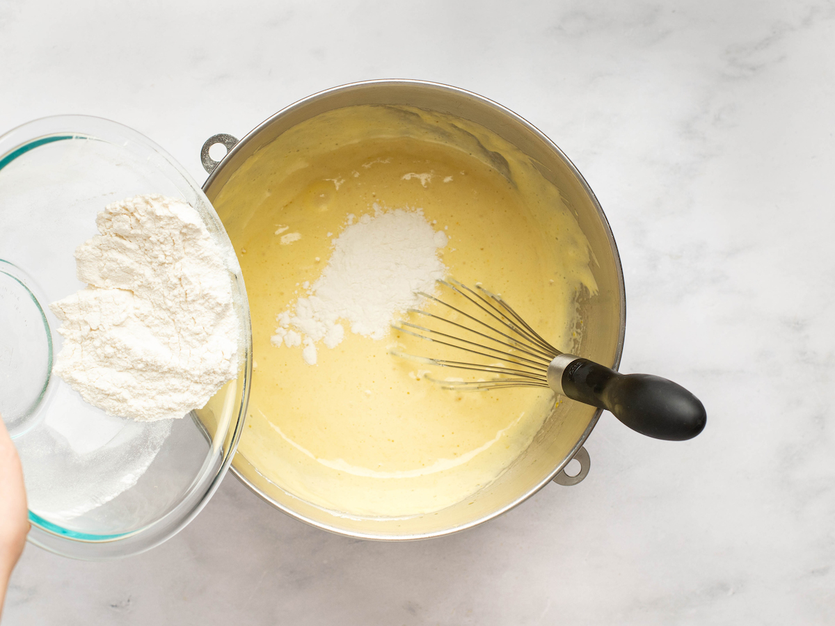 pouring remaining flour into egg and sugar mixture