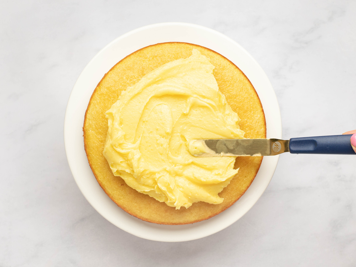 spreading pastry cream on cake