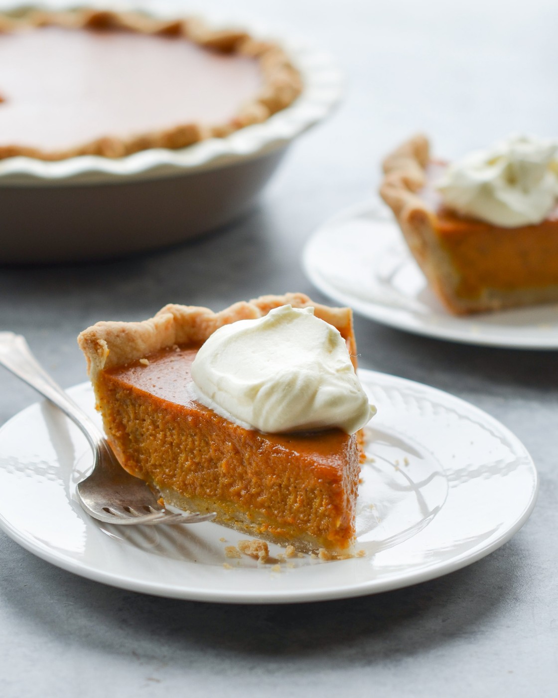 slice of pumpkin pie on plate with whipped cream