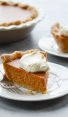 slice of pumpkin pie on plate with whipped cream