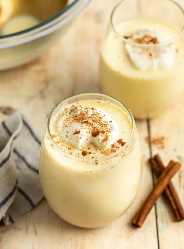 glasses of eggnog with cinnamon sticks.