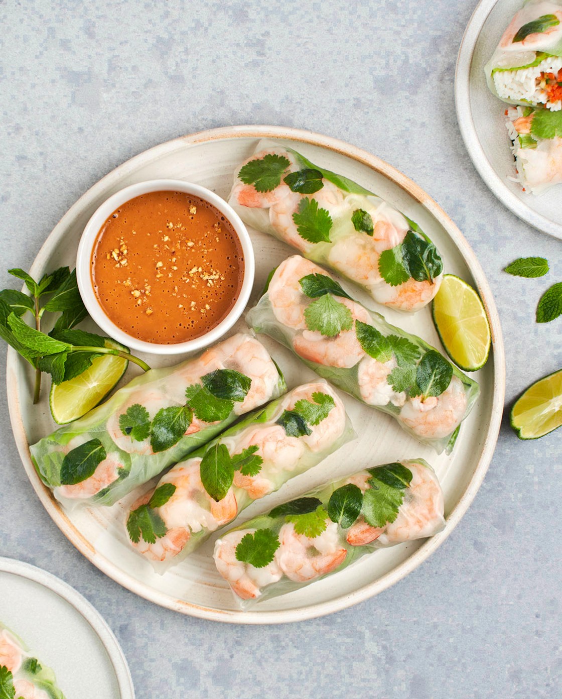 Vietnamese summer rolls on a platter with peanut dipping sauce and limes