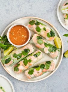 Vietnamese summer rolls on a platter with peanut dipping sauce and limes