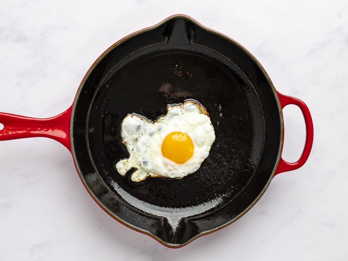 egg cooking in cast iron skillet