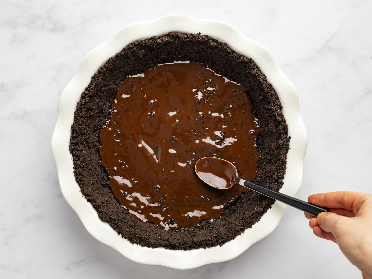 spreading the chocolate layer in the Oreo crust