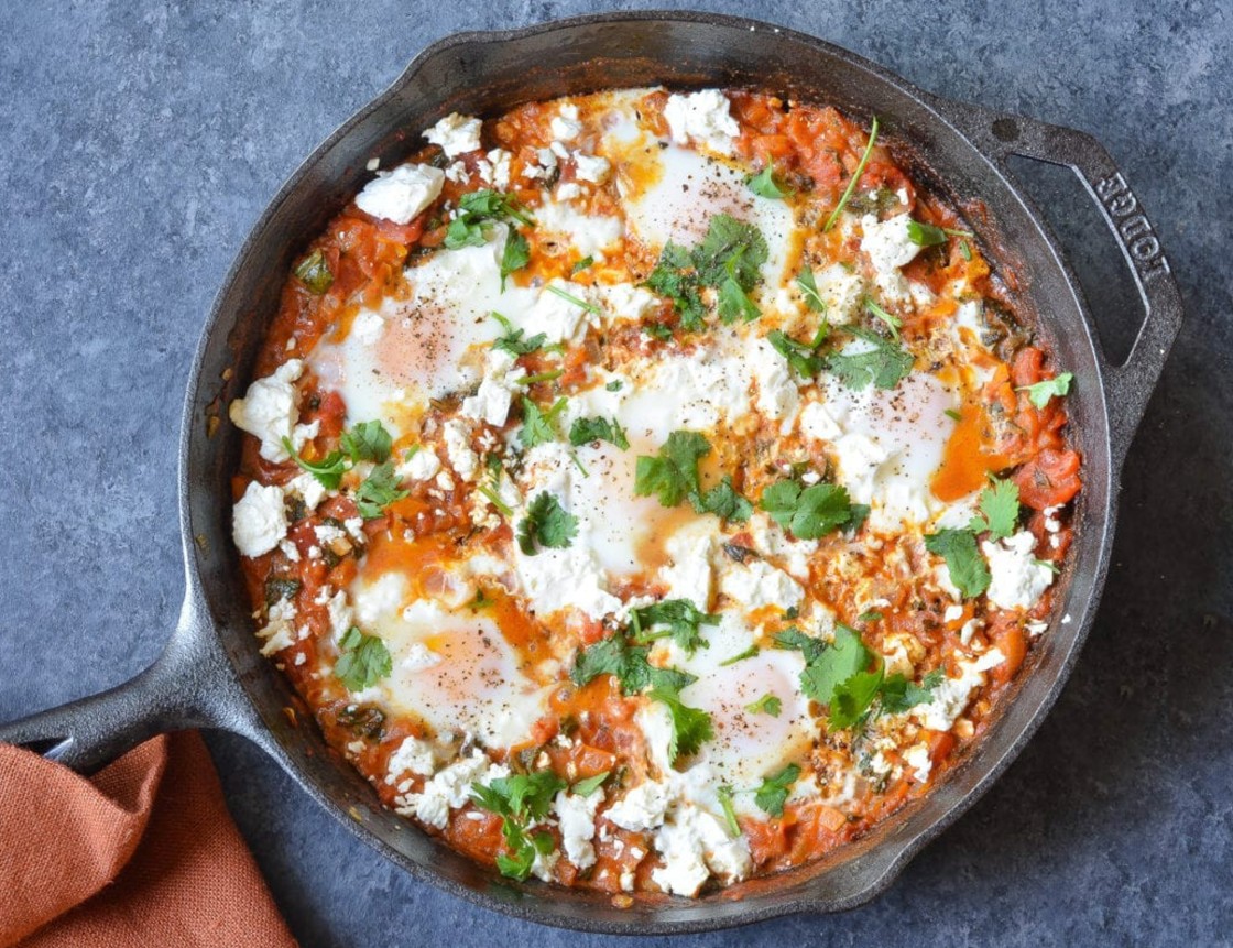 shakshuka in cast iron skillet with linen napkin.