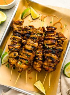thai grilled chicken with peanut sauce on tray.