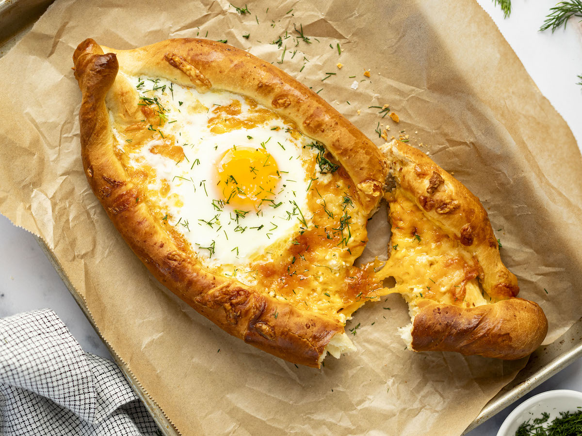 Torn khachapuri on baking sheet