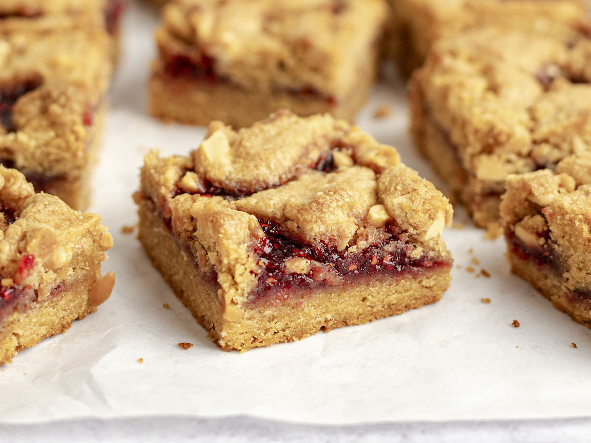baked and sliced PB&J bars on parchment paper