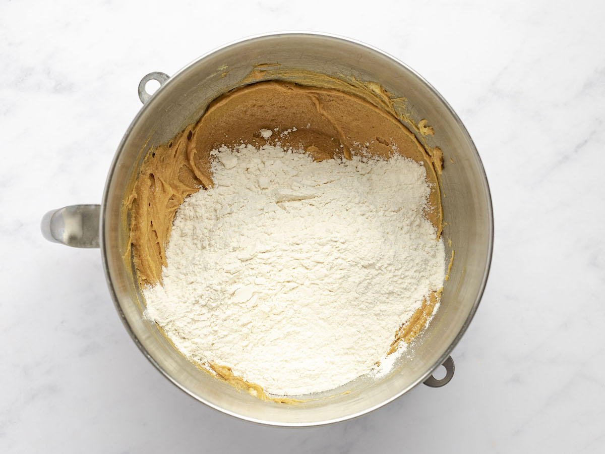 mixing bowl with flour added to peanut butter, egg, butter, and sugar mixture