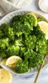 steamed broccoli in bowls with lemon wedges