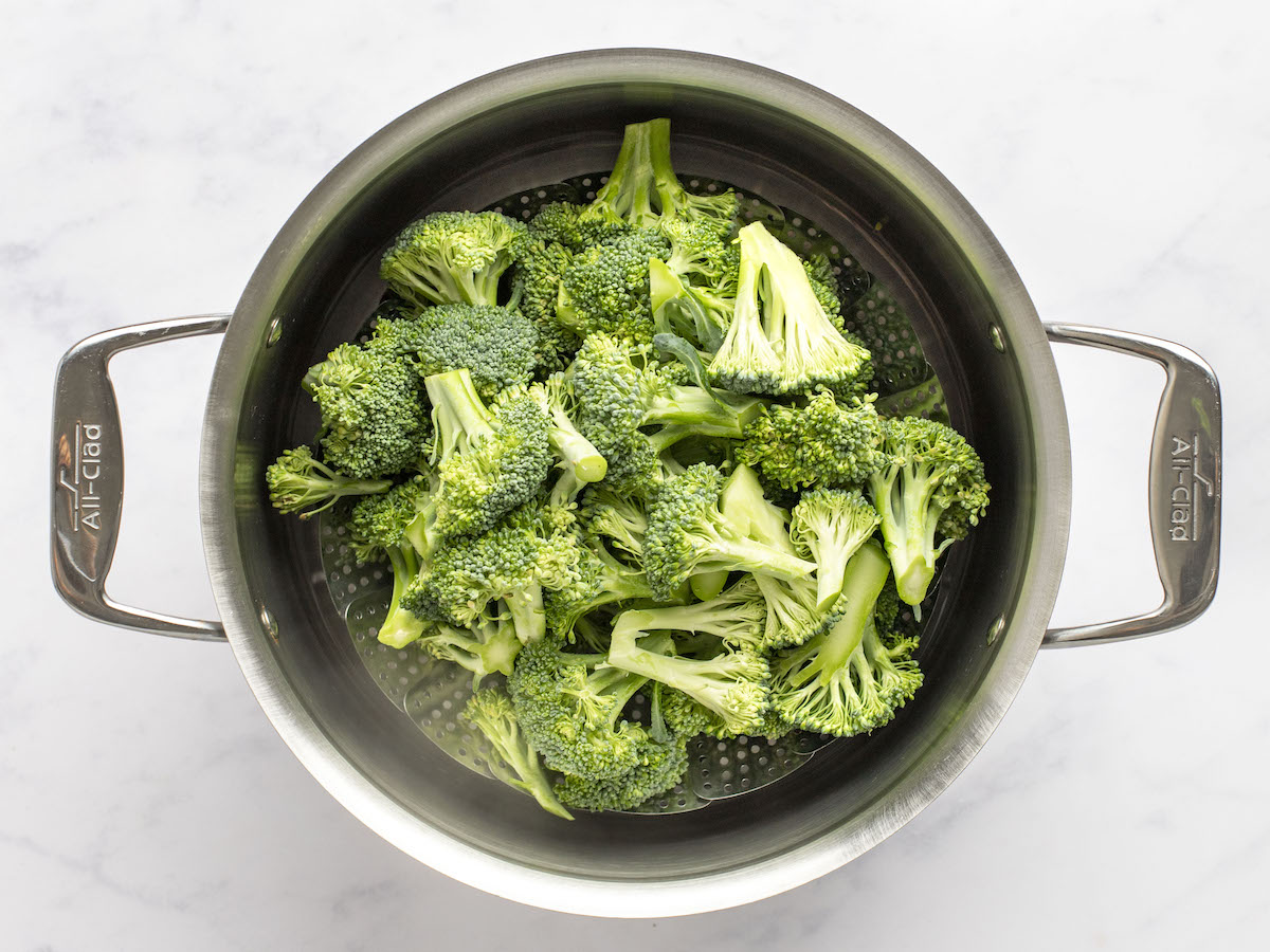 broccoli in steamer basket in large pot