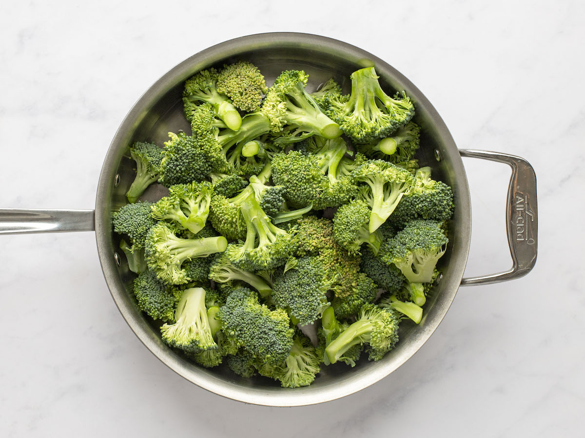 broccoli florets in skillet with water