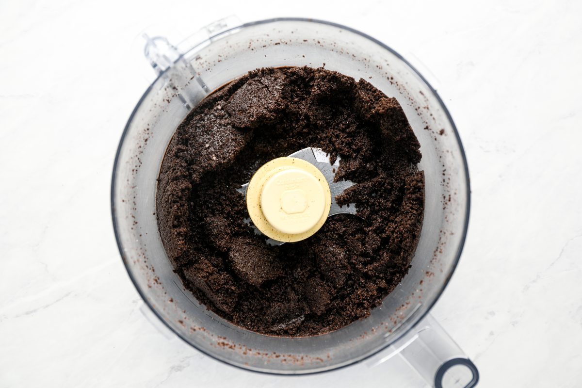 Oreos and butter finely chopped and combined in bowl of food processor