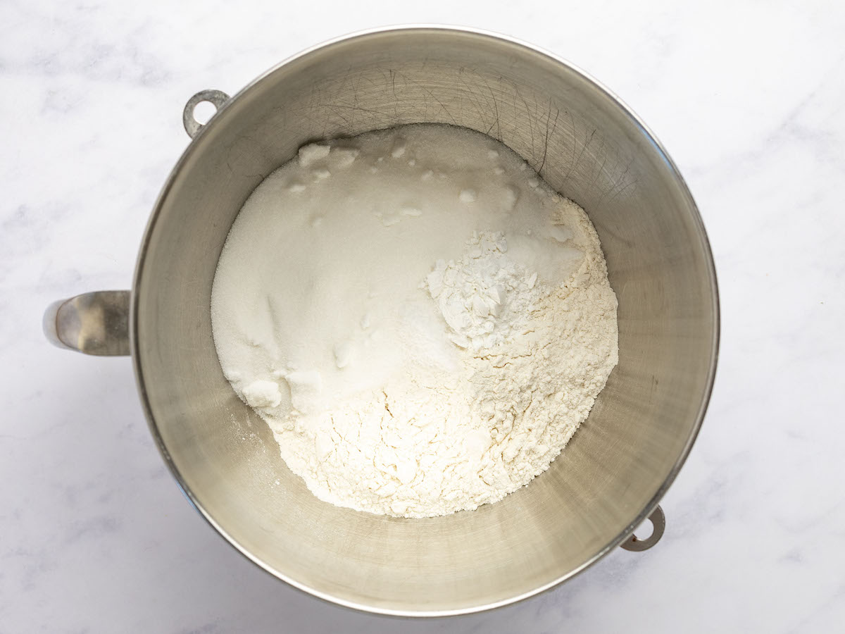 bowl of a stand mixer with flour, sugar, baking powder, and salt