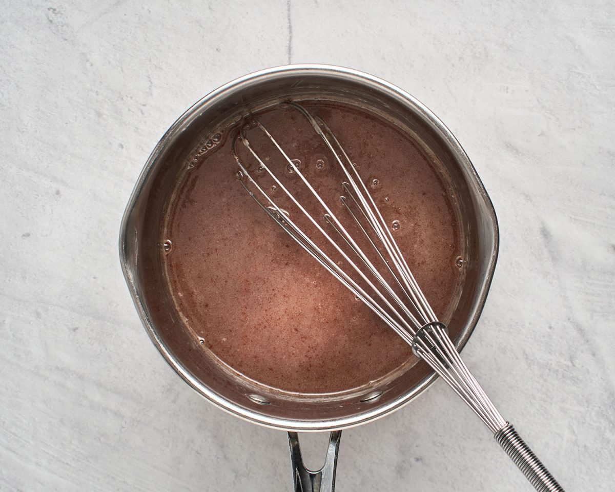 whisking melted chocolate into cream mixture in medium saucepan