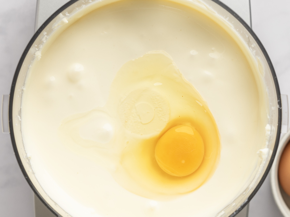 adding eggs to filling in food processor