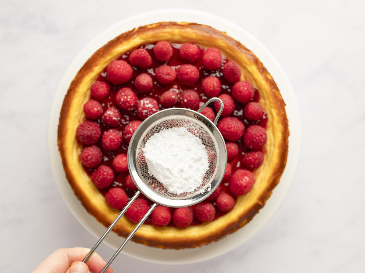 dusting ricotta cheesecake with confectioners sugar