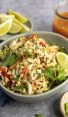 Vietnamese Shredded Chicken Salad in Bowl with Lime Wedges