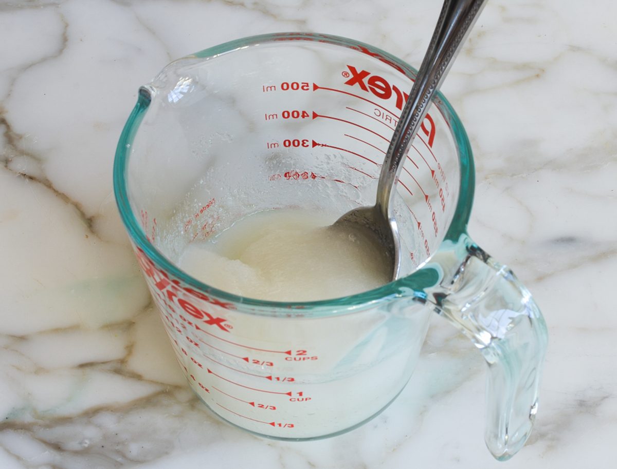 Stirring the sugar, corn syrup, water, and lemon juice together in a 500-ml microwave-safe measuring cup.