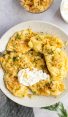 pierogi on plate with sour cream and onions