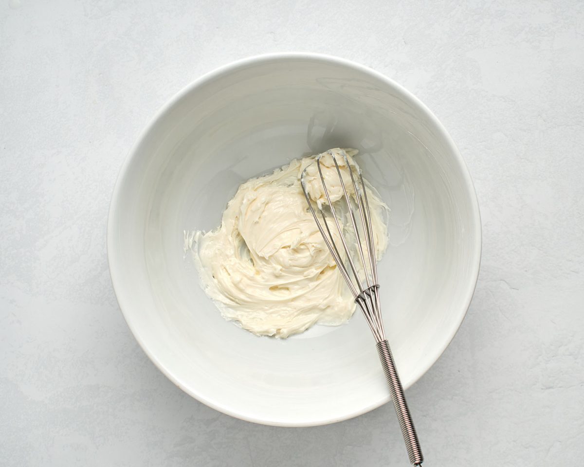 white bowl with cream cheese and whisk