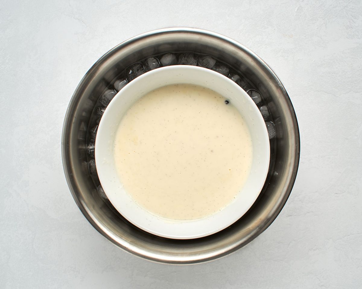 white bowl with ice cream mixture nestled in larger bowl with ice bath