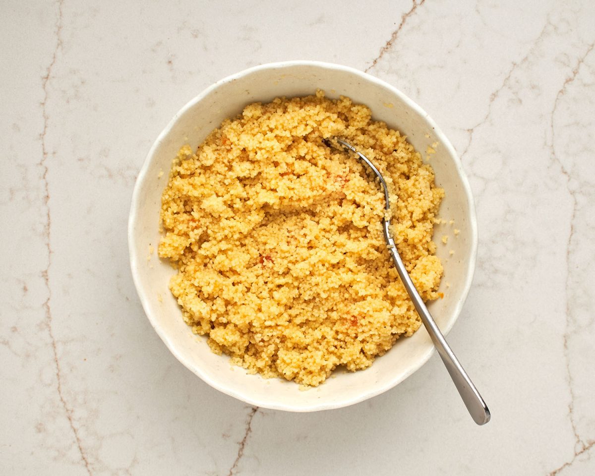 couscous in white bowl with vinaigrette mixed in