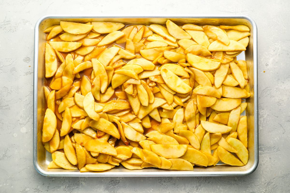 sliced cooked apples spread on baking sheet to cool